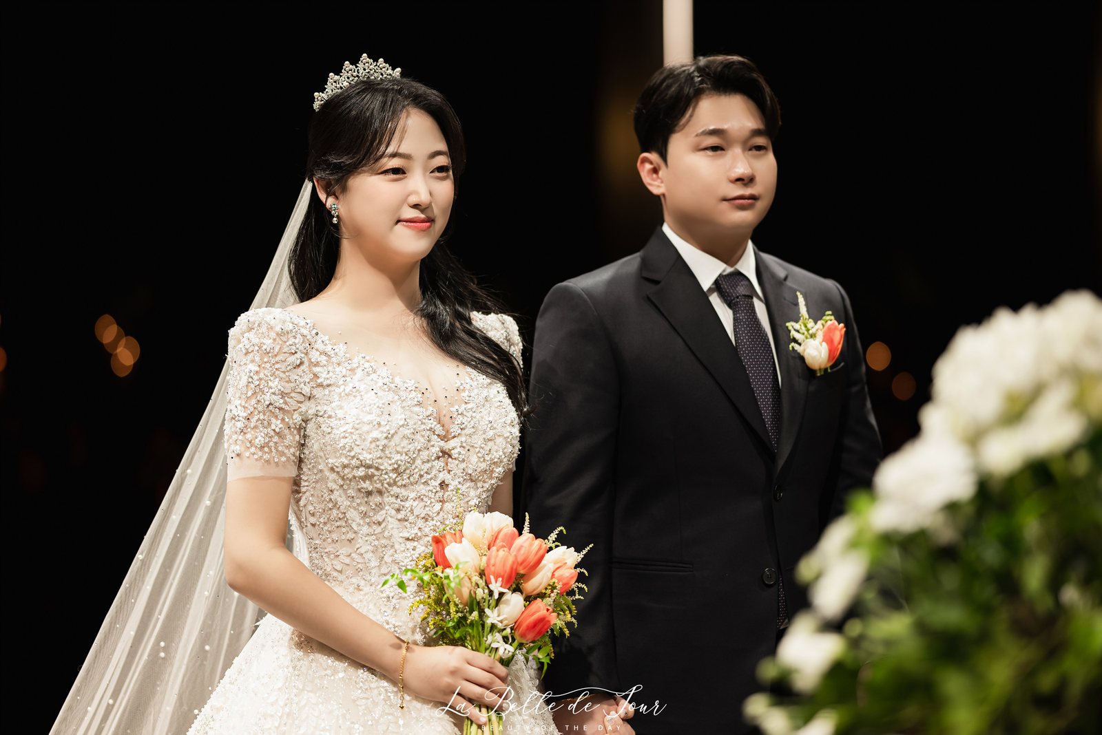 라벨드쥬 신도림 웨딩시티 그랜드볼룸 본식스냅 — 검은 배경 앞의 신랑신부