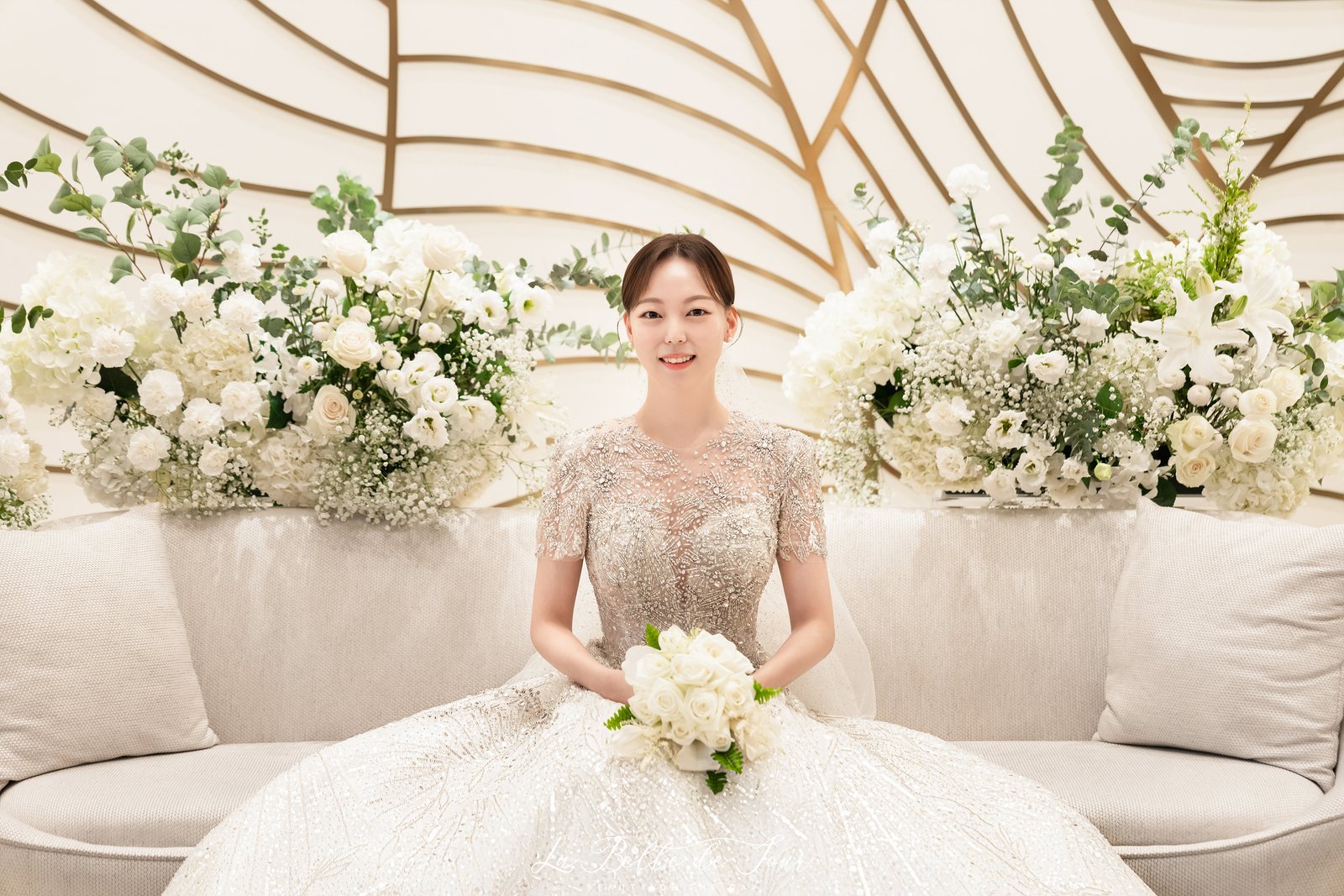 라벨드쥬 웨스턴베니비스 본식스냅 — 금색 선이 뻗은 대기실 벽 앞의 신부